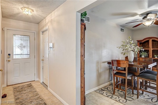 dining room featuring ceiling fan, a textured ceiling, and light tile patterned flooring