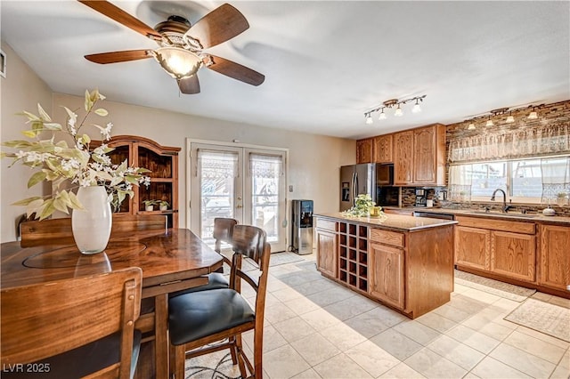 kitchen featuring sink, a center island, stainless steel fridge with ice dispenser, a healthy amount of sunlight, and french doors