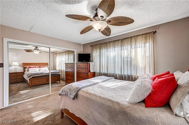 bedroom with ceiling fan, carpet floors, a textured ceiling, and a closet