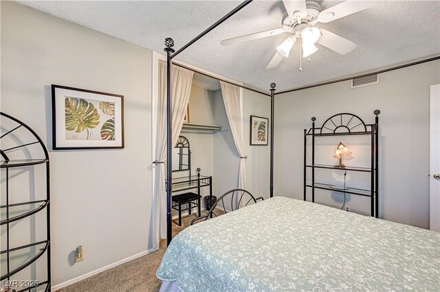 carpeted bedroom featuring ceiling fan and a textured ceiling