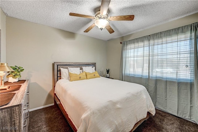 bedroom with ceiling fan, a textured ceiling, and dark colored carpet