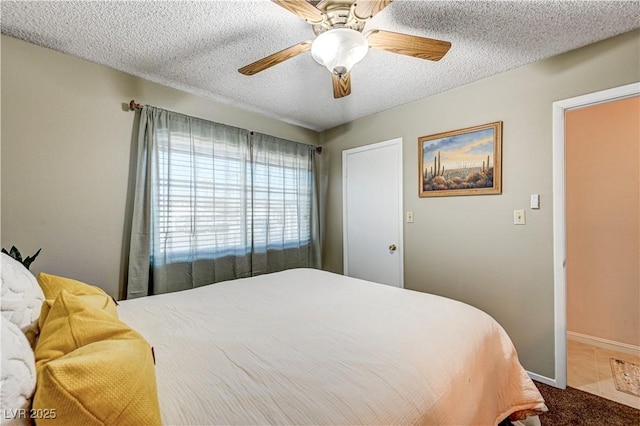 bedroom with ceiling fan, carpet floors, and a textured ceiling