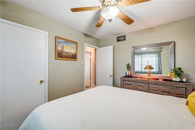 bedroom with ceiling fan and a textured ceiling