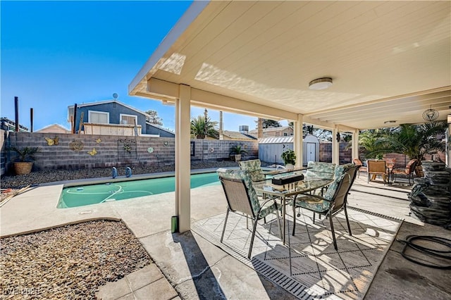 view of pool featuring a patio area and a storage shed