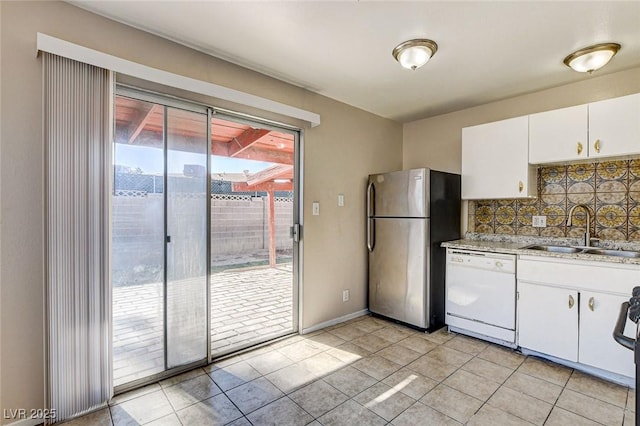 kitchen featuring tasteful backsplash, white cabinetry, sink, stainless steel fridge, and white dishwasher