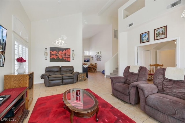 living room featuring an inviting chandelier, light tile patterned floors, and high vaulted ceiling