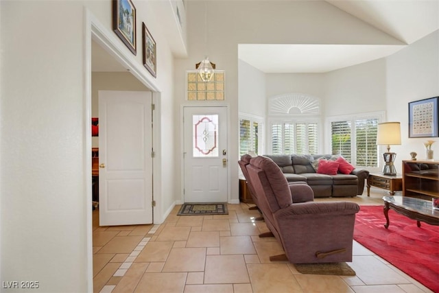 foyer entrance with light tile patterned floors and high vaulted ceiling