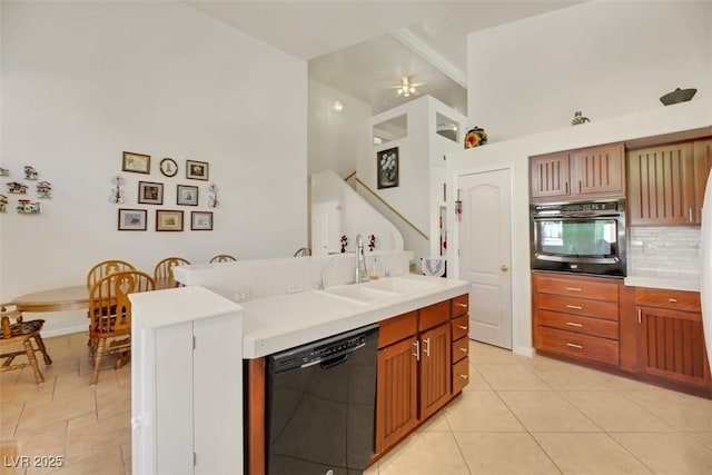 kitchen featuring sink, light tile patterned floors, backsplash, black appliances, and vaulted ceiling