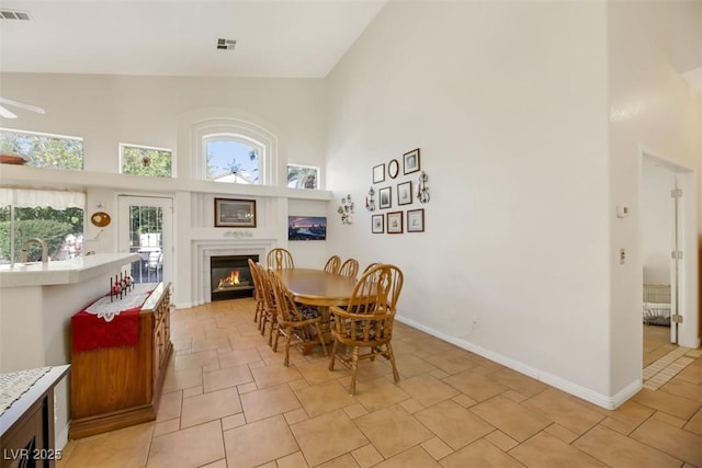 dining room with ceiling fan and high vaulted ceiling