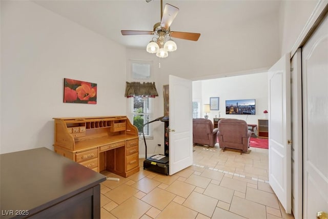 office space featuring ceiling fan and a high ceiling