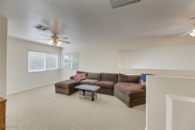 living room featuring light colored carpet, a textured ceiling, and ceiling fan