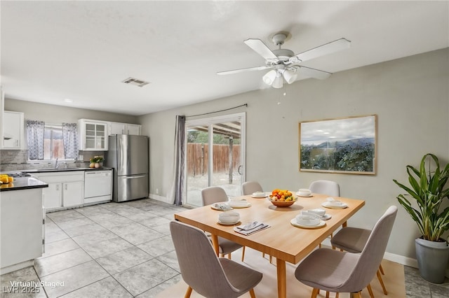 tiled dining space with sink and ceiling fan