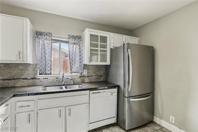 kitchen with stainless steel refrigerator, tasteful backsplash, white cabinetry, sink, and white dishwasher