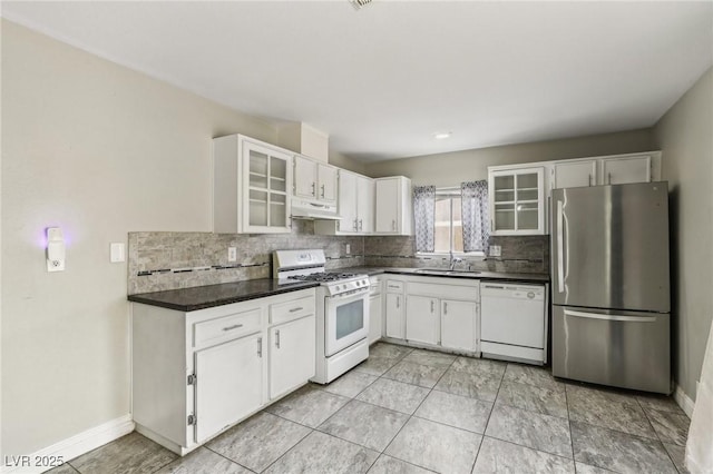 kitchen featuring white cabinetry, backsplash, and white appliances