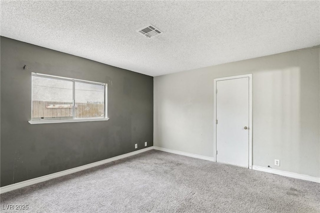 spare room featuring a textured ceiling and carpet flooring