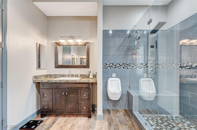 bathroom featuring vanity, wood-type flooring, and shower with separate bathtub