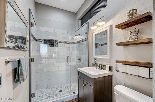 bathroom with vanity, toilet, and a shower with shower door