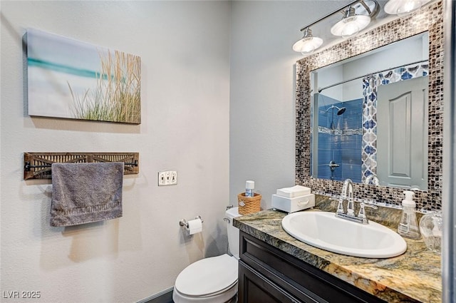 bathroom featuring vanity, a shower, and toilet