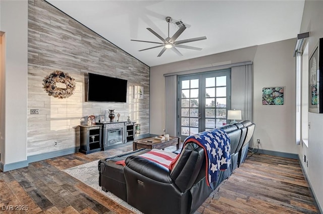 living room featuring lofted ceiling, dark hardwood / wood-style flooring, french doors, and ceiling fan