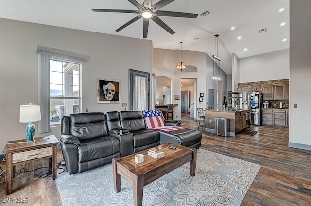 living room with ceiling fan, dark hardwood / wood-style flooring, and high vaulted ceiling