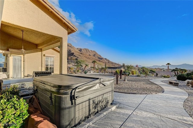 view of patio / terrace featuring a hot tub and a mountain view