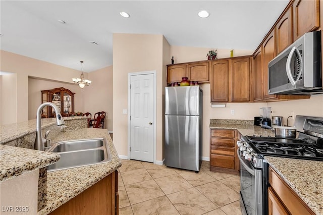 kitchen featuring sink, vaulted ceiling, hanging light fixtures, a notable chandelier, and stainless steel appliances