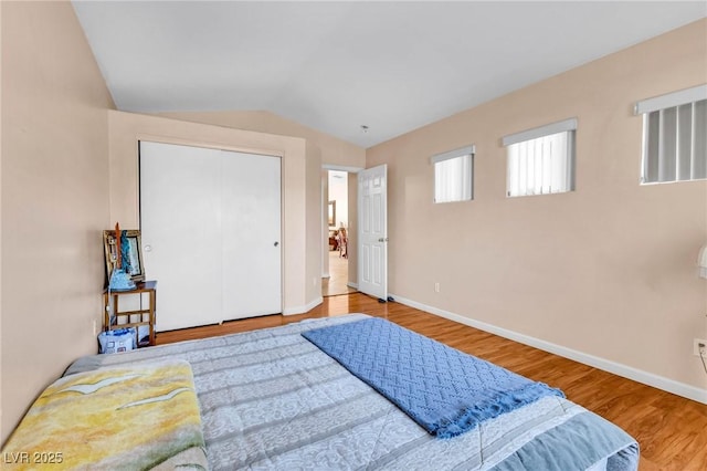 bedroom featuring lofted ceiling, hardwood / wood-style floors, and a closet