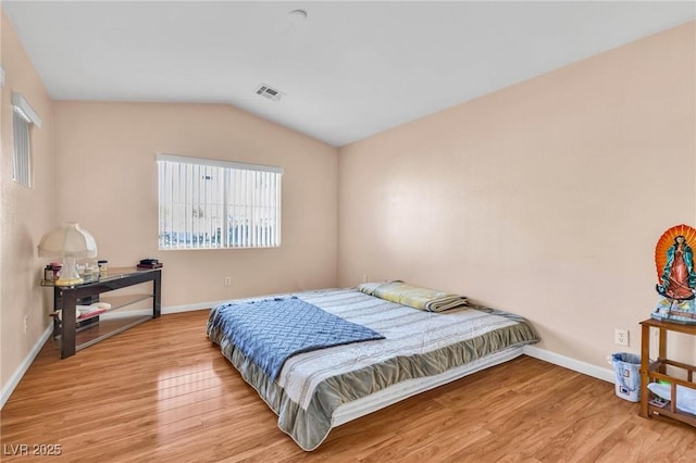 bedroom with lofted ceiling and light hardwood / wood-style flooring