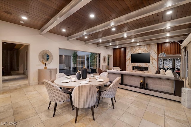 dining area featuring tile patterned floors, beamed ceiling, recessed lighting, a premium fireplace, and wood ceiling