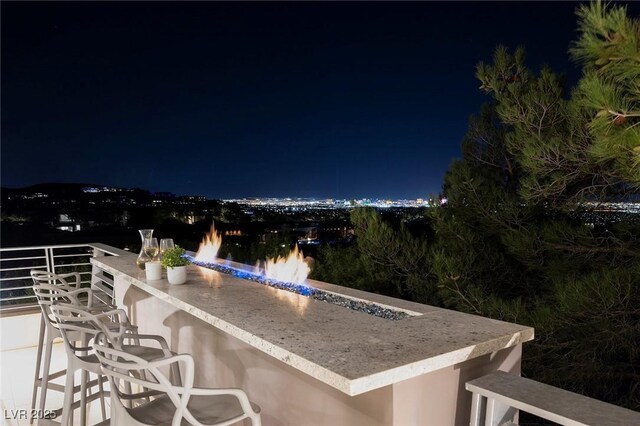 patio at twilight featuring outdoor dry bar