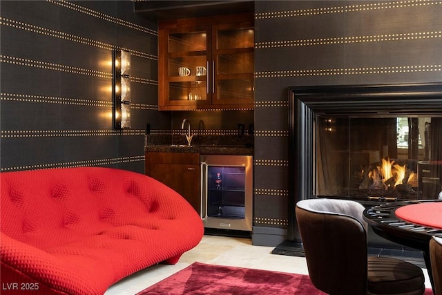 bar featuring a glass covered fireplace, wet bar, beverage cooler, and light tile patterned flooring