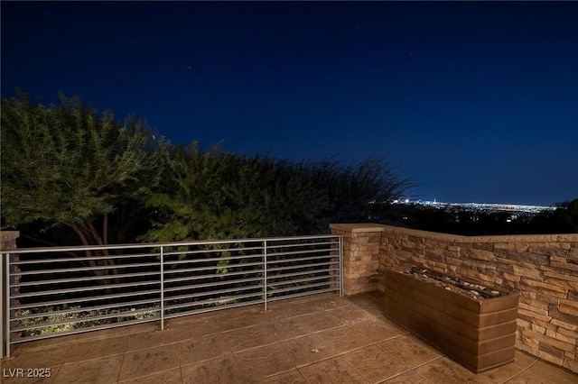 patio at night featuring a balcony