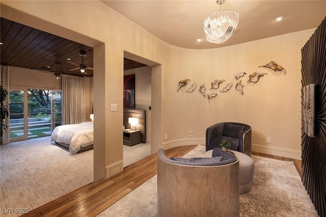 sitting room featuring baseboards, a notable chandelier, and wood finished floors