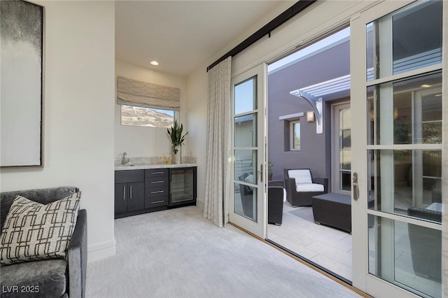 interior space featuring beverage cooler, a patio, and a sink