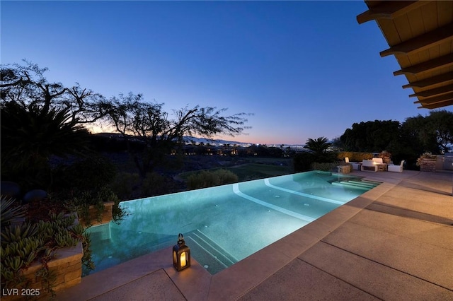 pool at dusk with a patio