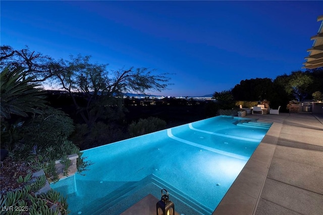 view of swimming pool featuring a patio and an infinity pool