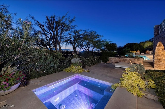 view of pool with a patio area and an in ground hot tub