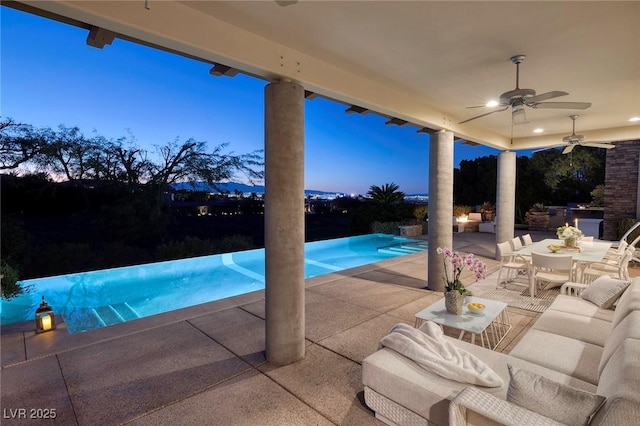 view of swimming pool featuring ceiling fan, outdoor lounge area, outdoor dining space, an infinity pool, and a patio