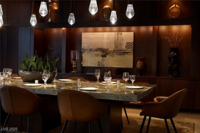 dining area with wet bar and wooden walls