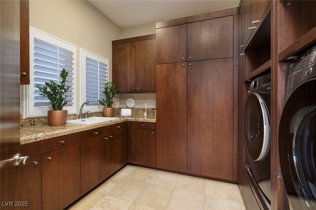 laundry room featuring washer and clothes dryer, cabinet space, and a sink