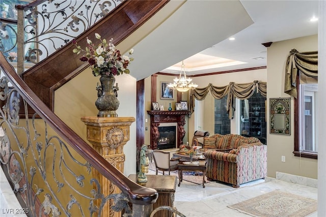 living room with crown molding, a tray ceiling, and a notable chandelier