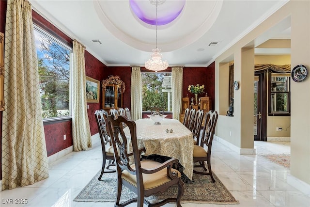 dining room with crown molding, a tray ceiling, and a chandelier