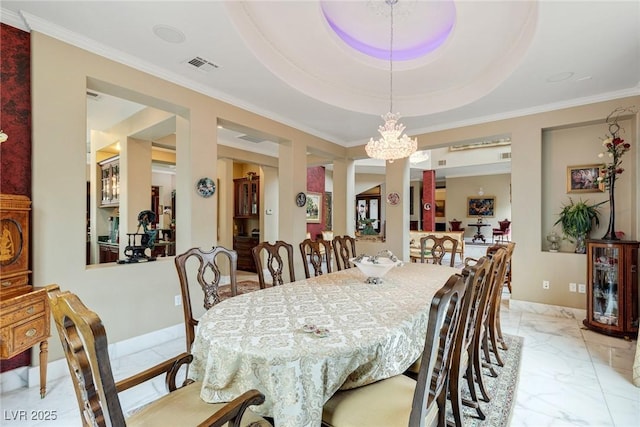 dining space featuring a raised ceiling, ornamental molding, and an inviting chandelier