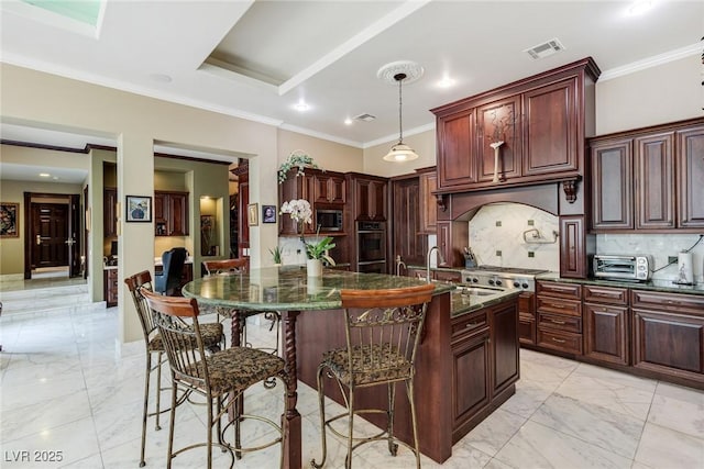 kitchen featuring a kitchen island with sink, hanging light fixtures, a kitchen breakfast bar, stainless steel appliances, and dark stone counters