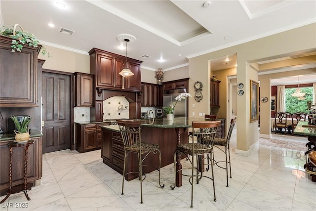 kitchen featuring a center island, ornamental molding, stainless steel built in fridge, and dark brown cabinets