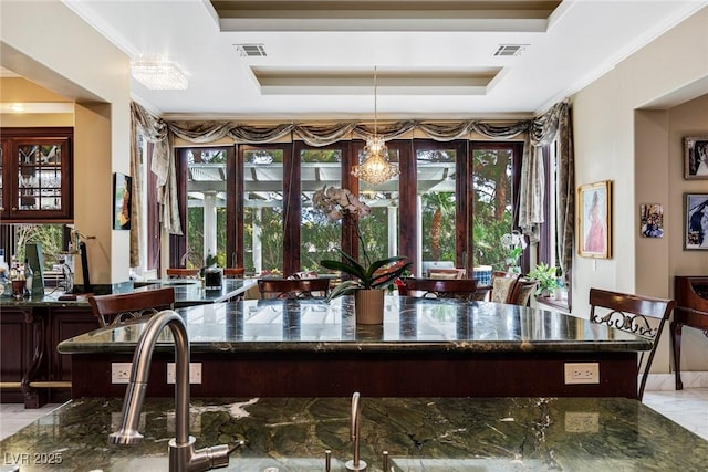 bar with crown molding, dark stone counters, and a raised ceiling