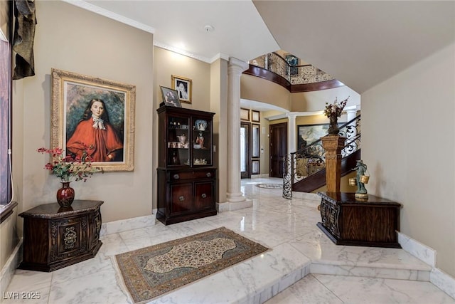 entrance foyer featuring decorative columns and crown molding