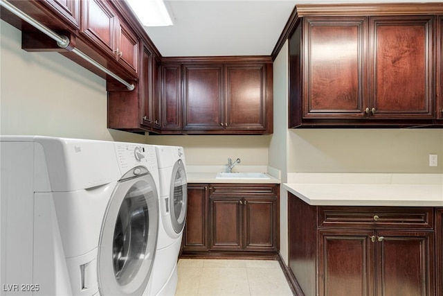 laundry area with washer and dryer, sink, light tile patterned floors, and cabinets