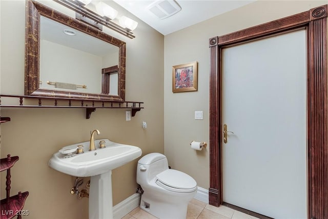 bathroom with toilet and tile patterned flooring