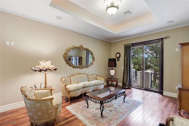 living room with a tray ceiling and hardwood / wood-style floors